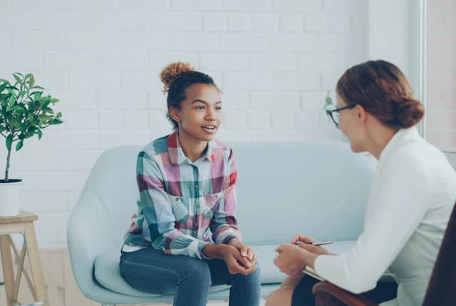 Patient speaking with a therapist during a clinical check-in.