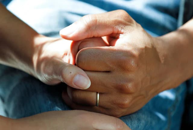 Supportive hands representing ongoing care and follow-up.